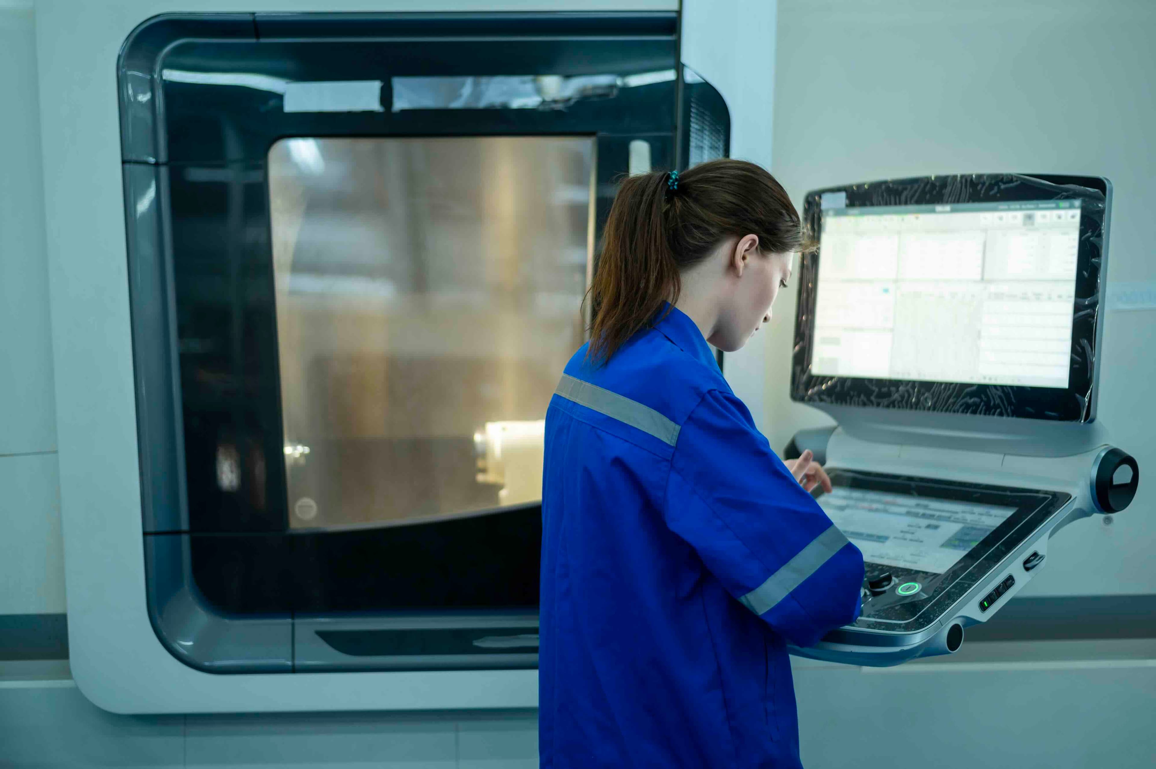 A technician operating heavy machinery in a modern manufacturing facility, representing how QReserve regulates equipment access control, enforces operator safety prerequisites, and monitors industrial asset utilization.